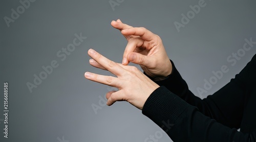 Close up of hands making a sign language gesture in muted studio lighting