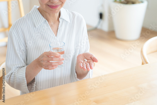 Obraz na płótnie 家で薬を飲むシニアの女性