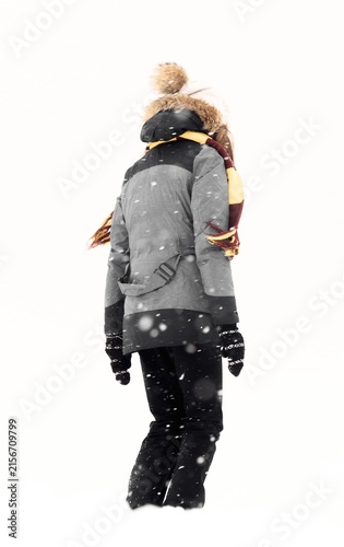 Person walking through falling snow in winter clothing