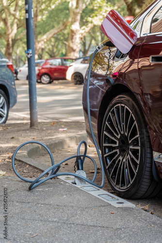 Ein E-Auto wird an einem Ladebordstein auf der KÖ mit einem Kabel aufgeladen, Düsseldorf, Deutschland