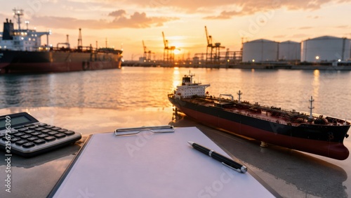 Model Oil Tanker Ship with Clipboard and Calculator at Sunset