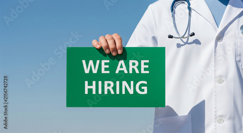 Medical recruitment concept with doctor holding we are hiring sign, healthcare professional seeking new staff, clinical job vacancy announcement