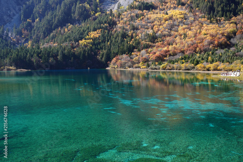 The breathtaking scenery of the crystal-clear turquoise lake with autumn colors at Jiuzhaigou National Park in Sichuan Province, China