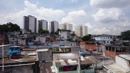 Drone going up behind a light pole revealing a humble neighborhood (Brasilândia) in São Paulo, Brazil.