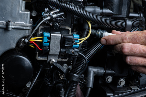 Installing New Spark Plug in Outboard Engine During Maintenance