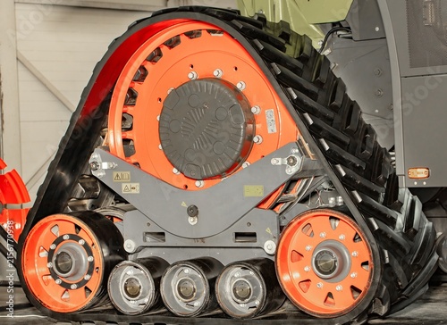 Heavy machinery track system shown in detail in a workshop setting during the day