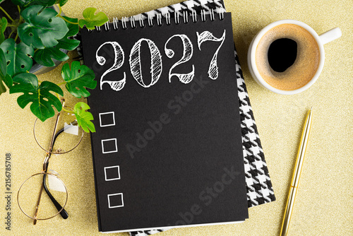 New year resolutions 2027 on desk. 2027 resolutions list with notebook, coffee cup on table. Goals, resolutions, plan, action, checklist concept. New Year 2027 template. Copy space