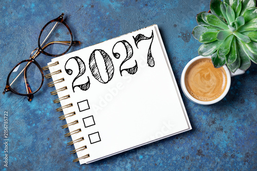 New year resolutions 2027 on desk. 2027 resolutions list with notebook, coffee cup on table. Goals, resolutions, plan, action, checklist concept. New Year 2027 template, copy space