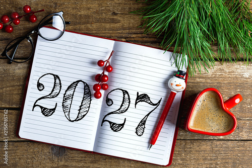 New year resolutions 2027 on desk. 2027 resolutions list with notebook, coffee cup on wooden table. Goals, resolutions, plan, action, checklist concept. New Year 2027 template, copy space