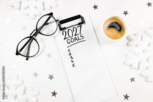 New year resolutions 2027 on desk. 2027 resolutions list with notebook, coffee cup on table. Goals, resolutions, plan, action, checklist concept. New Year 2027 template, copy space