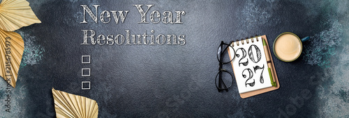 New year resolutions 2027 on desk. 2027 goals list with notebook, coffee cup, plant on wooden table. Resolutions, plan, goals, action, checklist, idea concept. New Year 2027 resolutions, copy space