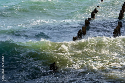 The remains of the wooden old pier in the Mediterranean Sea on a sunny day