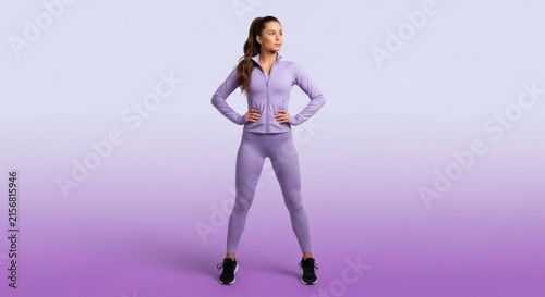 Athletic Woman in Purple Tracksuit Standing Confidently in Studio