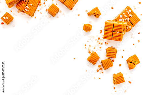 Canvas Print Salted caramel pieces - paradoxical sweets - on white background top view frame