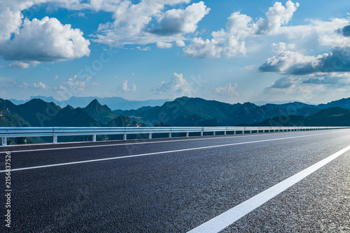 Фотография Asphalt highway running through a majestic mountain landscape under a clear blue