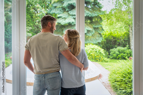 Rear view of a middle-aged couple looking out the window