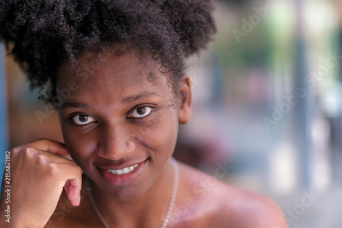 Smiling Young Black Woman with Natural Curly Hair Resting Chin on Hand, Beauty Portrait with Copy Space