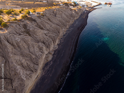 Принти на полотні Aerial drone shot over Vlichada black sand beach and wind eroded pumice cliffs i