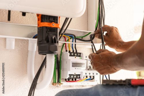 Closeup of technician installing solar photovoltaic hybrid inverter into a residential house