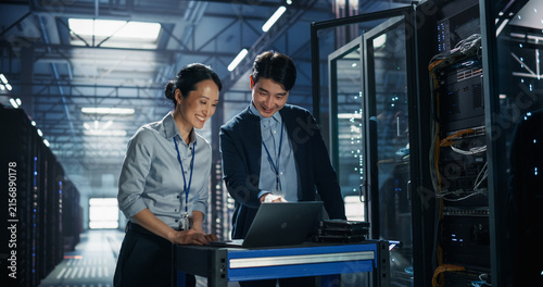 Konstfotografi Two Asian It Specialists, Man and Woman, Discuss Server Configuration on Laptop