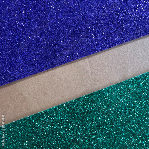 Blue and green glitter paper sheets separated by a beige strip
