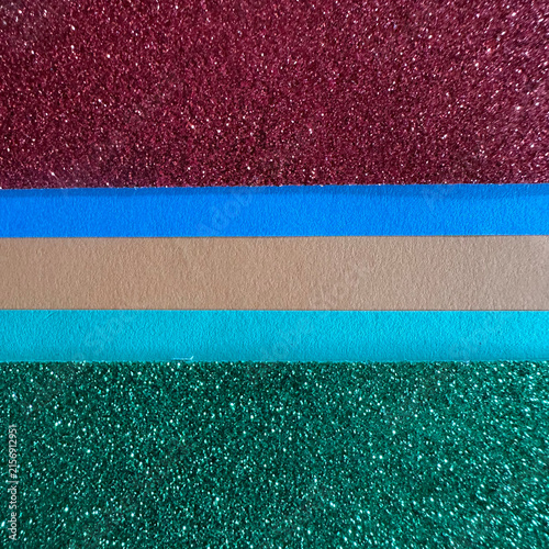 Horizontal stripes of glittering burgundy, blue, beige, teal, and green paper