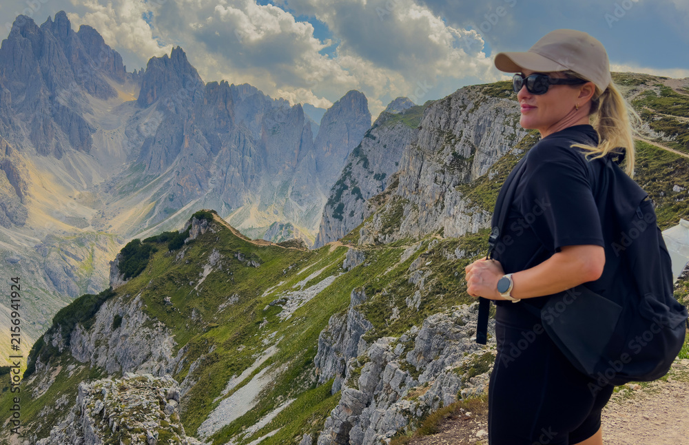 Obraz premium Young woman exploring hiking trail in Dolomites near Tre Cime Dolomites Italy