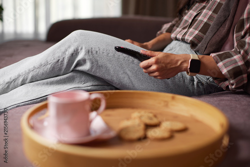 Obraz na płótnie Woman relaxing at home watching tv with cookies