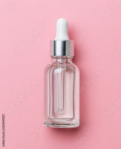Clear Glass Dropper Bottle with Cosmetic Serum or Essential Oil Isolated on Pastel Pink Background