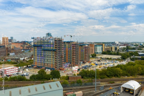Aerial photo of Leeds city centre showing a major high rise construction development with scaffolding tower crane railway tracks modern buildings and expanding urban architecture across West Yorkshire