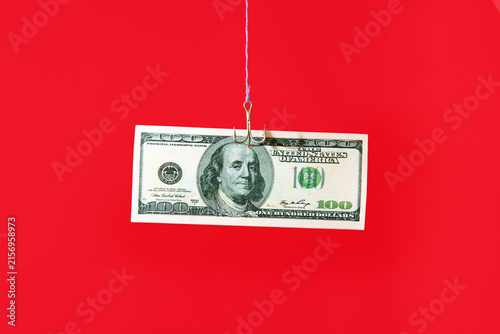 Dollar bill on hook over red background