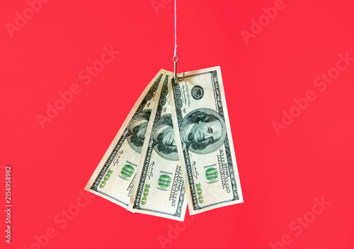 Dollar bills on hook over red background