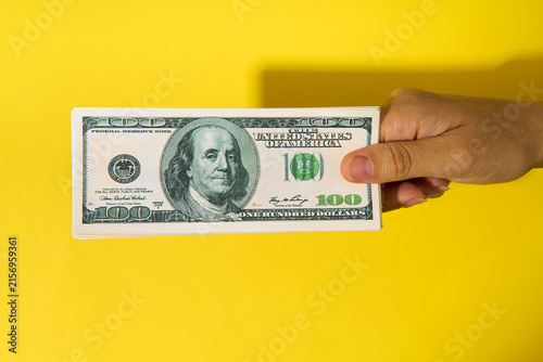 Hand holding stack of hundred dollar bills