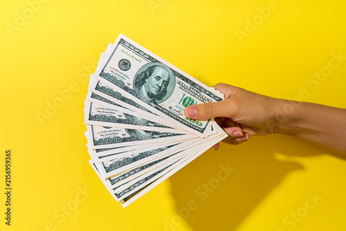 Hand holding fan of hundred dollar bills