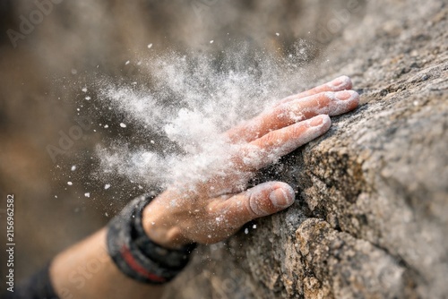 A person reaching out from a narrow opening in the rock, potentially escaping or seeking help