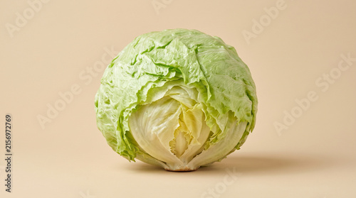 Fresh Raw Iceberg Lettuce Head Isolated on Beige Background for Healthy Food Concepts