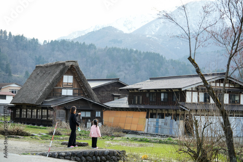 Mother and daughter travel in old wooden house in Shirakawa-go and Gokayama ogimachi village, a traditional gassho-zukuri style farmhouses village in the mountains  Gifu,Japan.