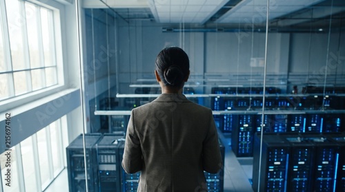 Woman Viewing Server Room Through Glass Wall