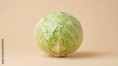 Fresh Iceberg Lettuce Head Isolated on Neutral Beige Background for Healthy Food Concepts