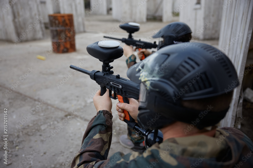 Naklejka premium Two soldiers point their guns at a target on a training field