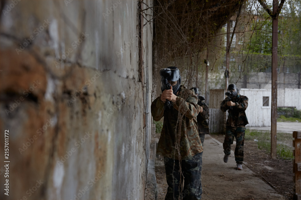 Fototapeta premium Soldiers point their weapons at a third soldier, ready to fire