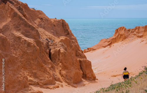 Person Walking Through Red Cliff Canyon to the Sea, Canoa Quebrada