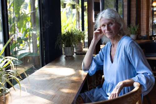 smiling senior woman portrait in cafe, mature female entrepreneur