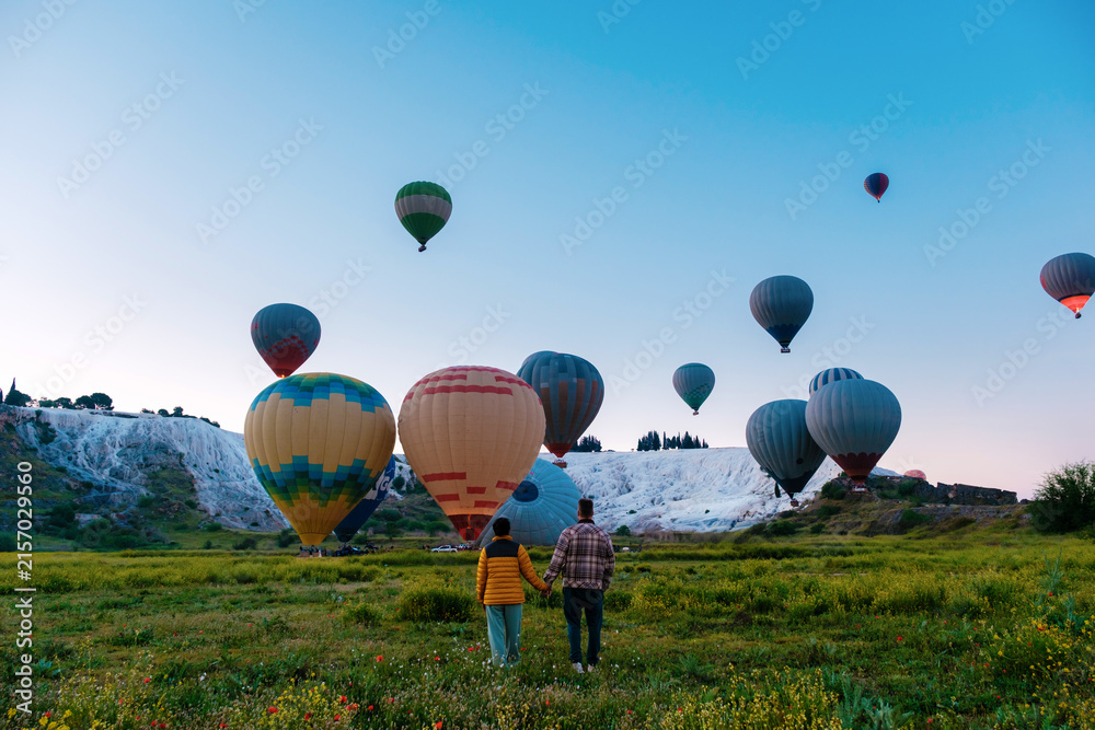 Fototapeta premium Hot air balloons drifting over the stunning travertine terraces of Pamukkale, Turkey