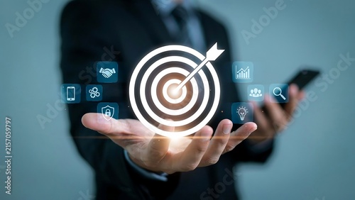 Business man holding target icon with digital marketing strategy and success symbols representing corporate goals and achievement