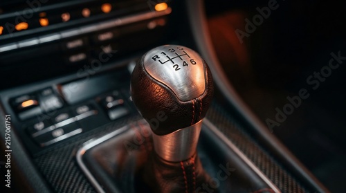 Close up of a manual gear shift knob with brushed metal details in a modern car interior