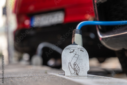 Ein E-Auto wird an einem Ladebordstein auf der KÖ mit einem Kabel aufgeladen, Düsseldorf, Deutschland