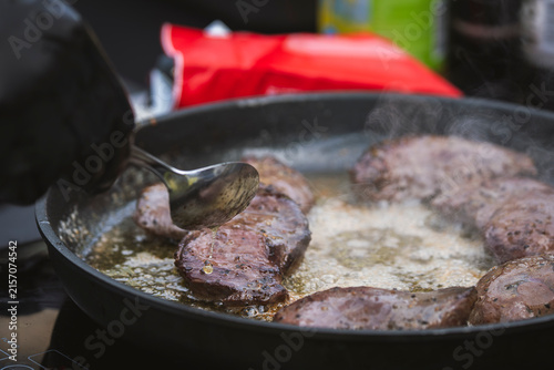 Canvas Print Cormorant breast fillets being pan-fried in butter, with a chef basting the meat in a hot skillet as steam rises, illustrating an unusual wild game cooking process and contemporary Nordic cuisine
