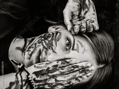 Black and white artistic portrait of woman with painted face and hands