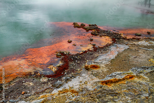 Obraz na plátne Orange microbial growth and mineral deposits line the edge of a steaming Champag